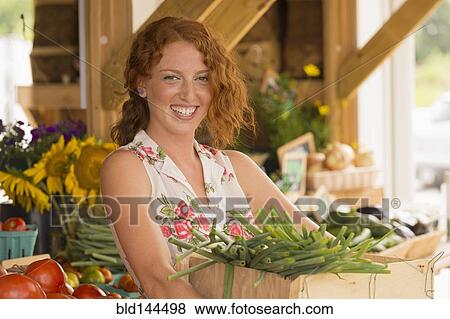 Caucasian woman carrying produce at farmers market View Large Photo Image Stock Photo - Caucasian woman carrying produce at farmers market. Fotosearch