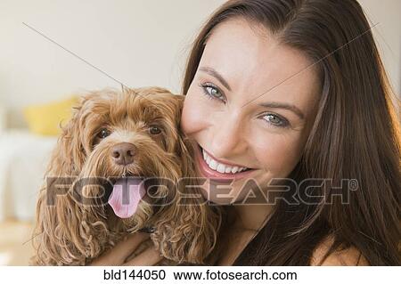 Stock Image - Caucasian woman holding pet dog. Fotosearch