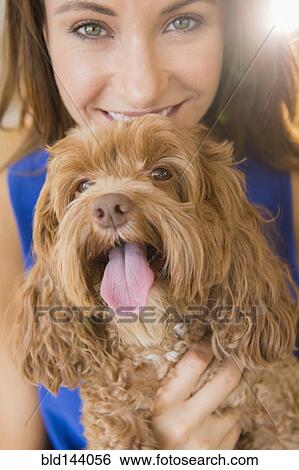 Stock Photograph - Caucasian woman holding pet dog. Fotosearch