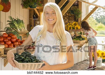 Caucasian woman holding produce at farmers market View Large Photo Image Stock Image - Caucasian woman holding produce at farmers market. Fotosearch