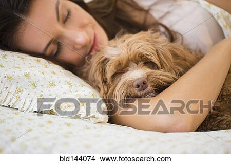 Caucasian woman hugging pet dog in bed View Large Photo Image Picture - Caucasian woman hugging pet dog in bed. Fotosearch