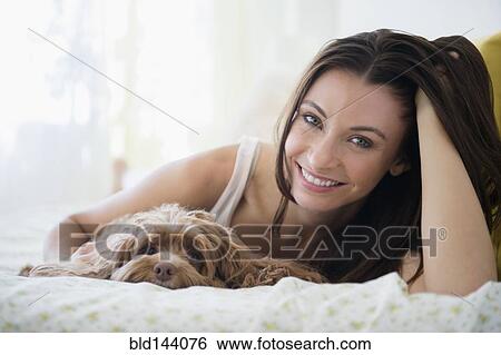 Caucasian woman hugging pet dog in bed View Large Photo Image Stock Photograph - Caucasian woman hugging pet dog in bed. Fotosearch