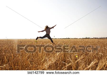 Caucasian woman jumping for joy in rural field View Large Photo Image Stock Photo - Caucasian woman jumping for joy in rural field. Fotosearch
