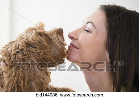 Stock Photograph - Caucasian woman kissing pet dog. Fotosearch