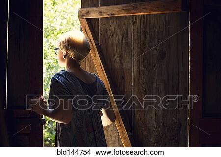 Caucasian woman looking out barn door View Large Photo Image Picture - Caucasian woman looking out barn door. Fotosearch