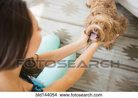 Picture - Caucasian woman petting dog. Fotosearch