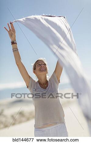 Caucasian woman playing with scarf on sand dune View Large Photo Image Stock Photo - Caucasian woman playing with scarf on sand dune. Fotosearch