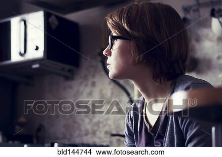 Picture - Caucasian woman sitting in kitchen. Fotosearch