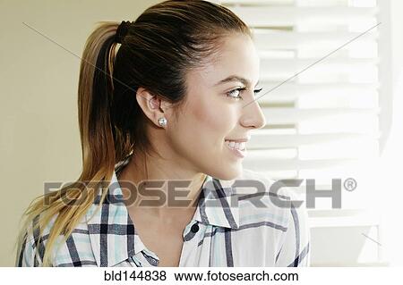 Caucasian woman smiling at window View Large Photo Image Stock Photo - Caucasian woman smiling at window. Fotosearch