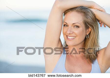Stock Photo - Caucasian woman smiling on beach. Fotosearch