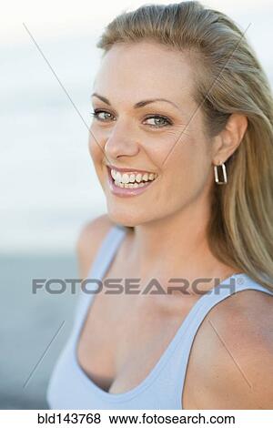 Stock Photo - Caucasian woman smiling on beach. Fotosearch