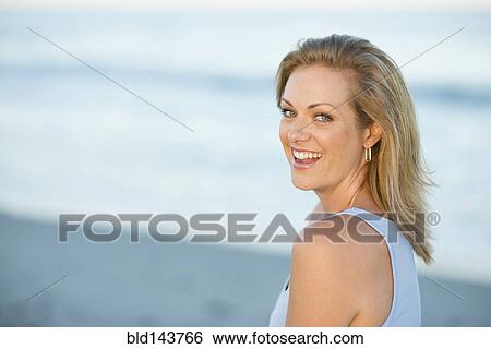 Stock Photograph - Caucasian woman smiling on beach. Fotosearch