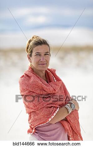 Stock Photograph - Caucasian woman smiling on sand dune. Fotosearch