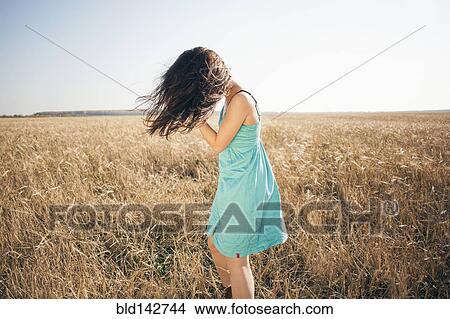 Picture - Caucasian woman standing in rural field. Fotosearch