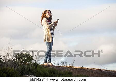 Caucasian woman using cell phone outdoors View Large Photo Image Picture - Caucasian woman using cell phone outdoors. Fotosearch
