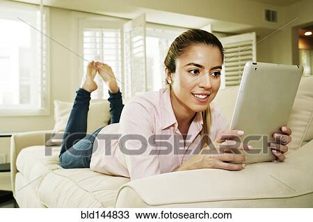 Caucasian woman using digital tablet on sofa View Large Photo Image Stock Image - Caucasian woman using digital tablet on sofa. Fotosearch
