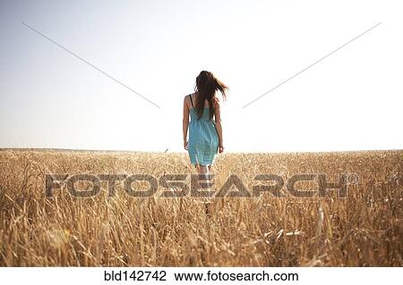 Caucasian woman walking in rural field View Large Photo Image Stock Image - Caucasian woman walking in rural field. Fotosearch