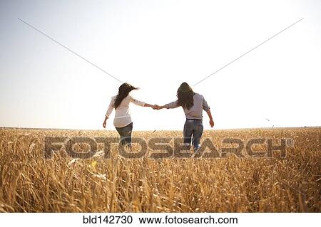 Caucasian women holding hands in rural field View Large Photo Image Stock Image - Caucasian women holding hands in rural field. Fotosearch