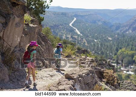 Stock Photo - Children hiking together on rocky mountainside. Fotosearch