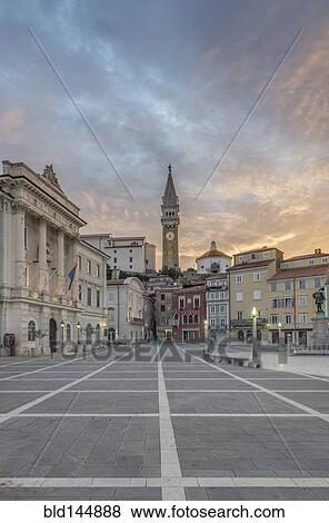 Stock Photo - Clock tower, buildings and town square at sunrise, Piran, Coastal-Karst, Slovenia. Fotosearch