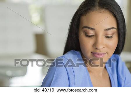 Close up of Black woman looking down View Large Photo Image Stock Photo - Close up of Black woman looking down. Fotosearch