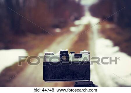 Stock Photo - Close up of camera on tripod on snowy road. Fotosearch