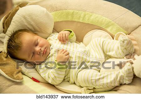 Close up of Caucasian baby boy sleeping on cushion View Large Photo Image Stock Photo - Close up of Caucasian baby boy sleeping on cushion. Fotosearch