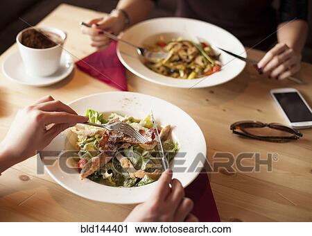 Close up of friends eating salads in cafe View Large Photo Image Stock Image - Close up of friends eating salads in cafe. Fotosearch