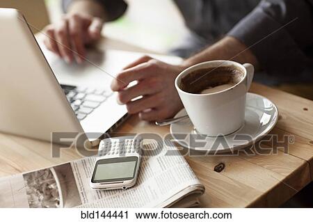 Close up of man using laptop with cup of coffee in cafe View Large Photo Image Stock Image - Close up of man using laptop with cup of coffee in cafe. Fotosearch