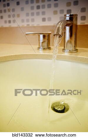 Close up of water flowing from faucet in sink View Large Photo Image Stock Image - Close up of water flowing from faucet in sink. Fotosearch