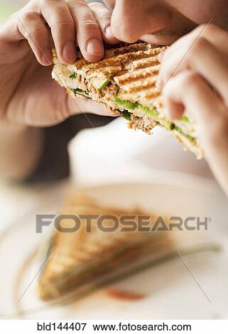Stock Photo - Close up of woman eating sandwich. Fotosearch
