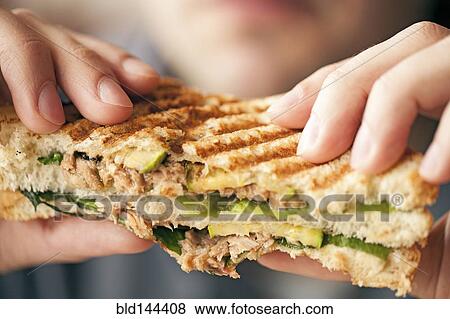 Stock Photo - Close up of woman eating sandwich. Fotosearch