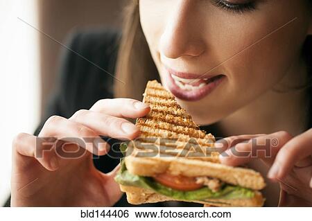 Close up of woman eating sandwich View Large Photo Image Stock Photograph - Close up of woman eating sandwich. Fotosearch
