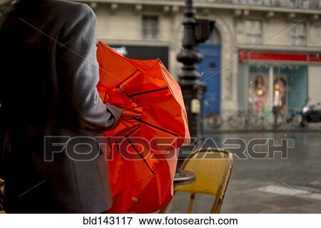 Close up of woman opening umbrella on rainy city street View Large Photo Image Stock Photo - Close up of woman opening umbrella on rainy city street. Fotosearch