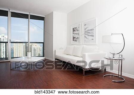Stock Photo - Coffee table, sofa and windows in modern living room. Fotosearch
