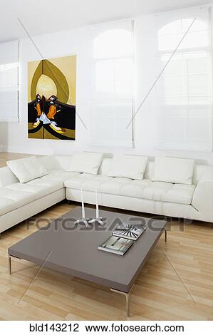 Stock Image - Coffee table, sofas and wall art in modern living room. Fotosearch