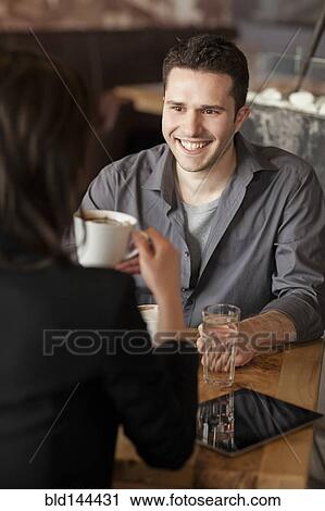 Stock Image - Couple drinking coffee in cafe. Fotosearch