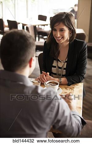 Stock Image - Couple drinking coffee in cafe. Fotosearch