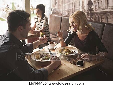Stock Photography - Couple eating in cafe. Fotosearch