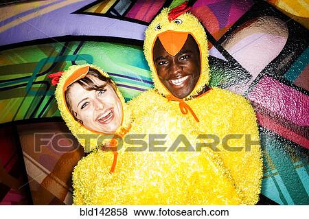 Couple in chicken costumes smiling near graffiti wall View Large Photo Image Stock Photo - Couple in chicken costumes smiling near graffiti wall. Fotosearch