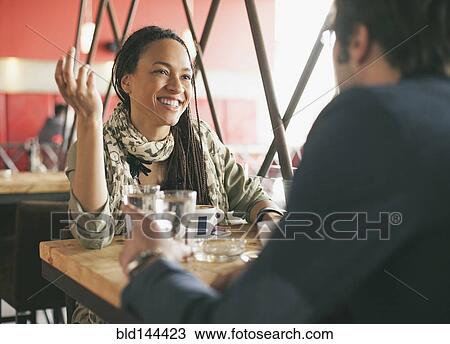 Stock Image - Couple talking in cafe. Fotosearch