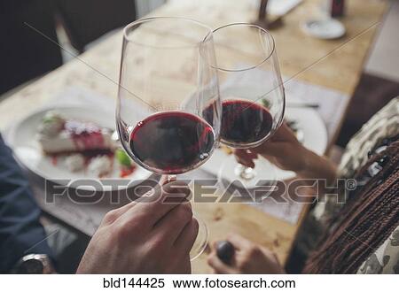 Couple toasting with wine in cafe View Large Photo Image Stock Photography - Couple toasting with wine in cafe. Fotosearch