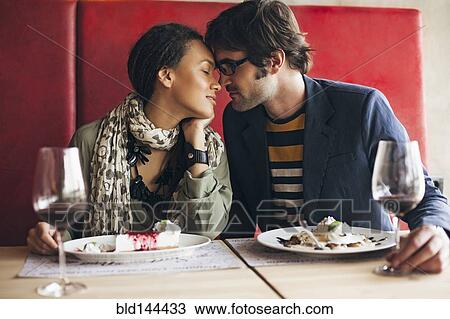 Stock Image - Couple touching foreheads in cafe. Fotosearch