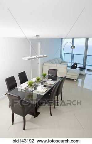 Stock Image - Dining room and sofa in modern apartment. Fotosearch