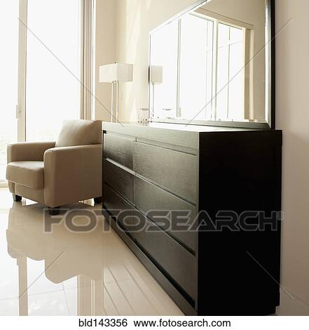 Dresser, mirror and armchair in modern bedroom View Large Photo Image Stock Photograph - Dresser, mirror and armchair in modern bedroom. Fotosearch