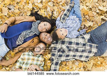 Family laying together in autumn leaves View Large Photo Image Stock Photography - Family laying together in autumn leaves. Fotosearch