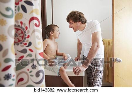 Father and son talking in bathroom View Large Photo Image Stock Image - Father and son talking in bathroom. Fotosearch