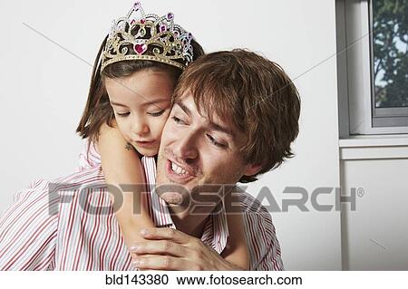 Stock Image - Father carrying daughter in tiara. Fotosearch