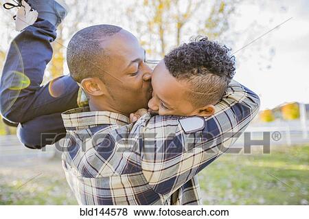 Stock Photo - Father kissing son outdoors. Fotosearch