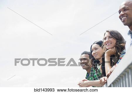 Friends admiring view from banister View Large Photo Image Stock Image - Friends admiring view from banister. Fotosearch